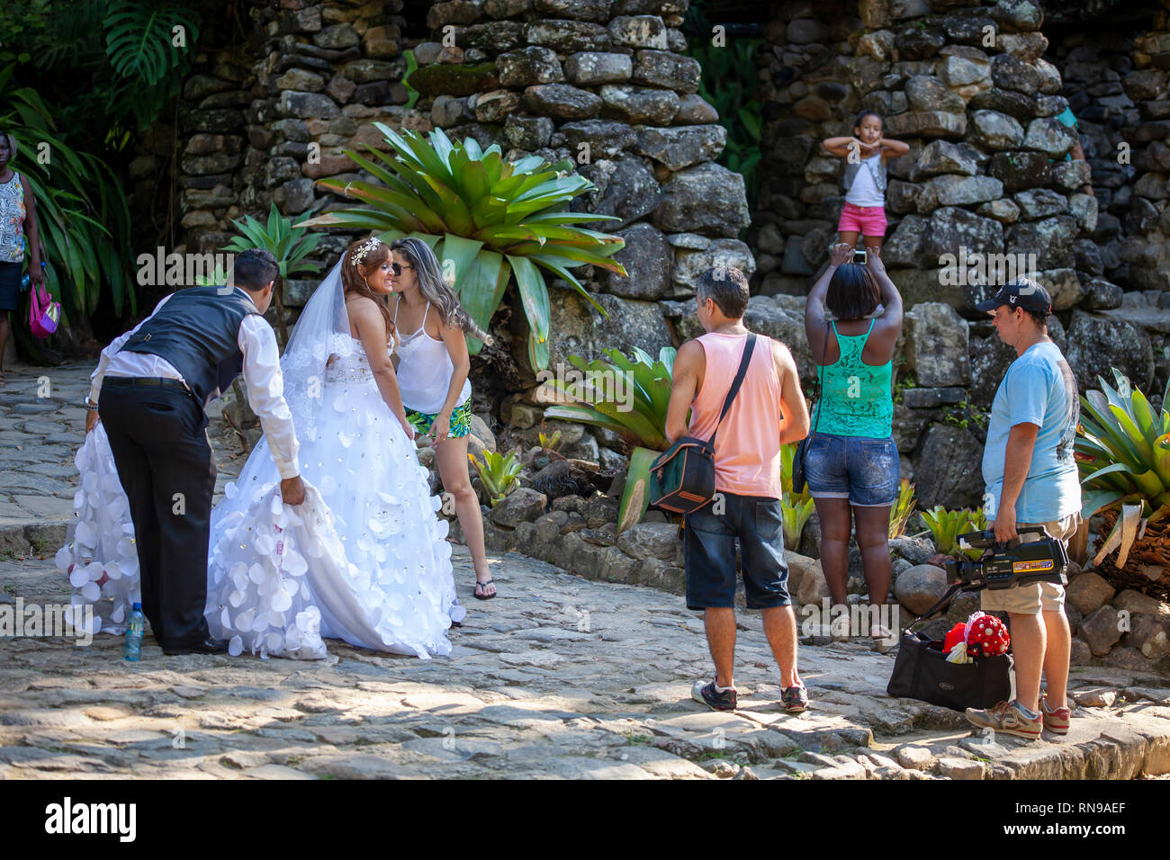 Braut fotografie Session in der botanische Garten von Rio de Janeiro, während ein Mädchen für ein Foto im Hintergrund Posing ist Stockfoto