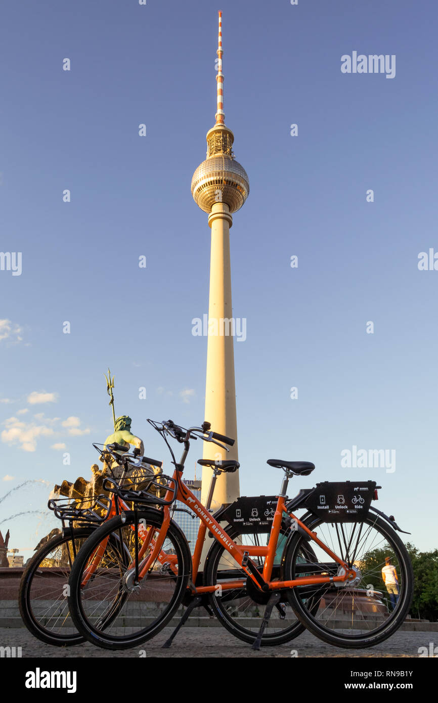 Berlin/Deutschland - vom 1. Juli 2018: zwei dockless Leihfahrräder vom Esel Republik Bike Sharing Unternehmen vor dem Fernsehturm Berlin (Berliner Fernseht Stockfoto