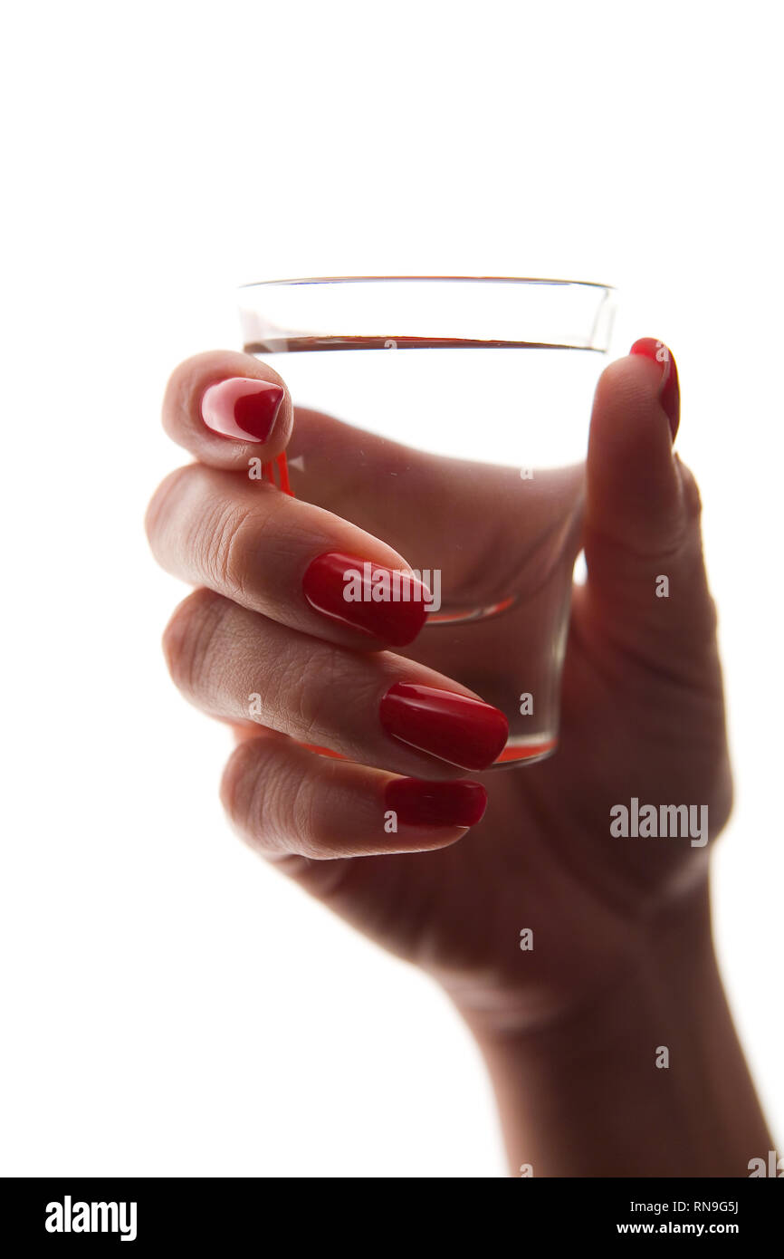 Weibliche hand mit einem schönen Maniküre Holding ein Glas. Auf weissem Hintergrund closeup Isolieren. Stockfoto