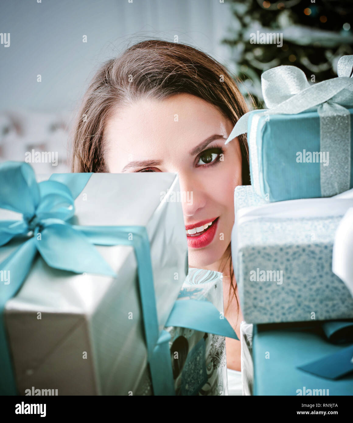 Hübsche, junge Frau mit einem Bündel Geschenkboxen Stockfoto