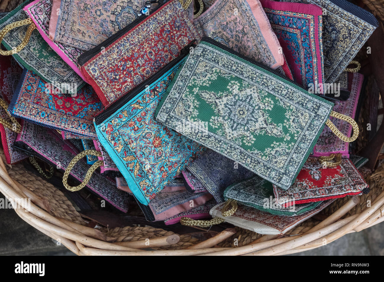 Einfache, Geldbörsen oder Taschen mit Reißverschluss zum Verkauf in Souvenir Shop Warenkorb. Muster sind zarte, geometrischen und vertrackt. Stockfoto