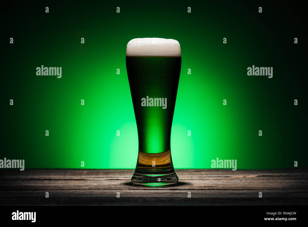 Glas ale stehen auf hölzernen Tisch auf st patricks day auf grünem Hintergrund Stockfoto