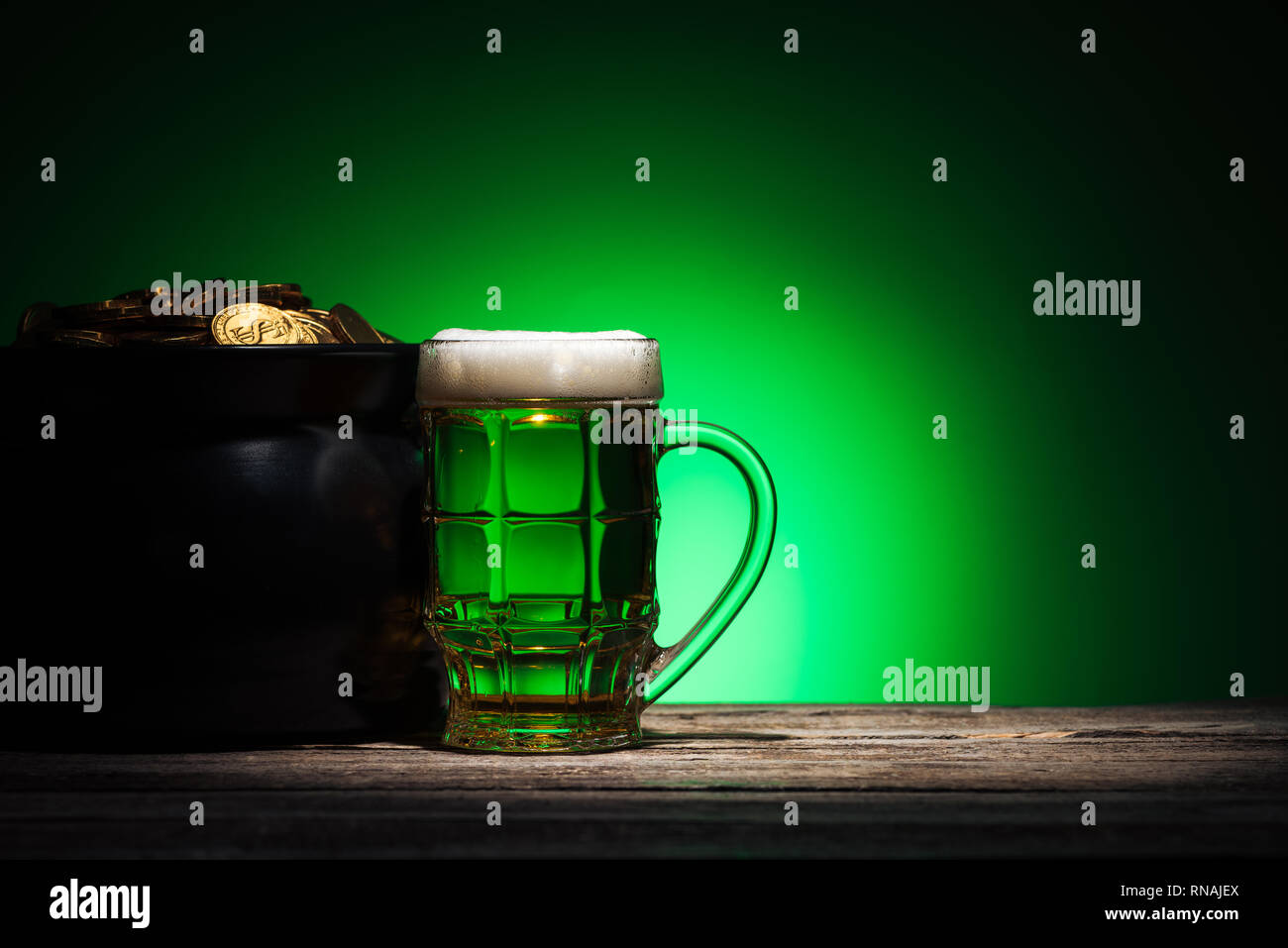 Glas Ale in der Nähe von Topf mit Gold auf st patricks day auf grünem Hintergrund Stockfoto