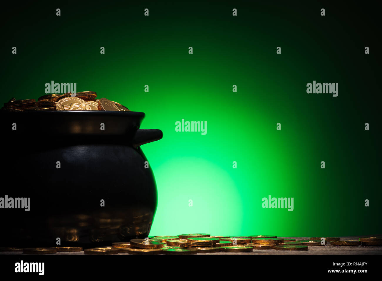 Topf mit goldenen Münzen auf st patricks day auf grünem Hintergrund Stockfoto