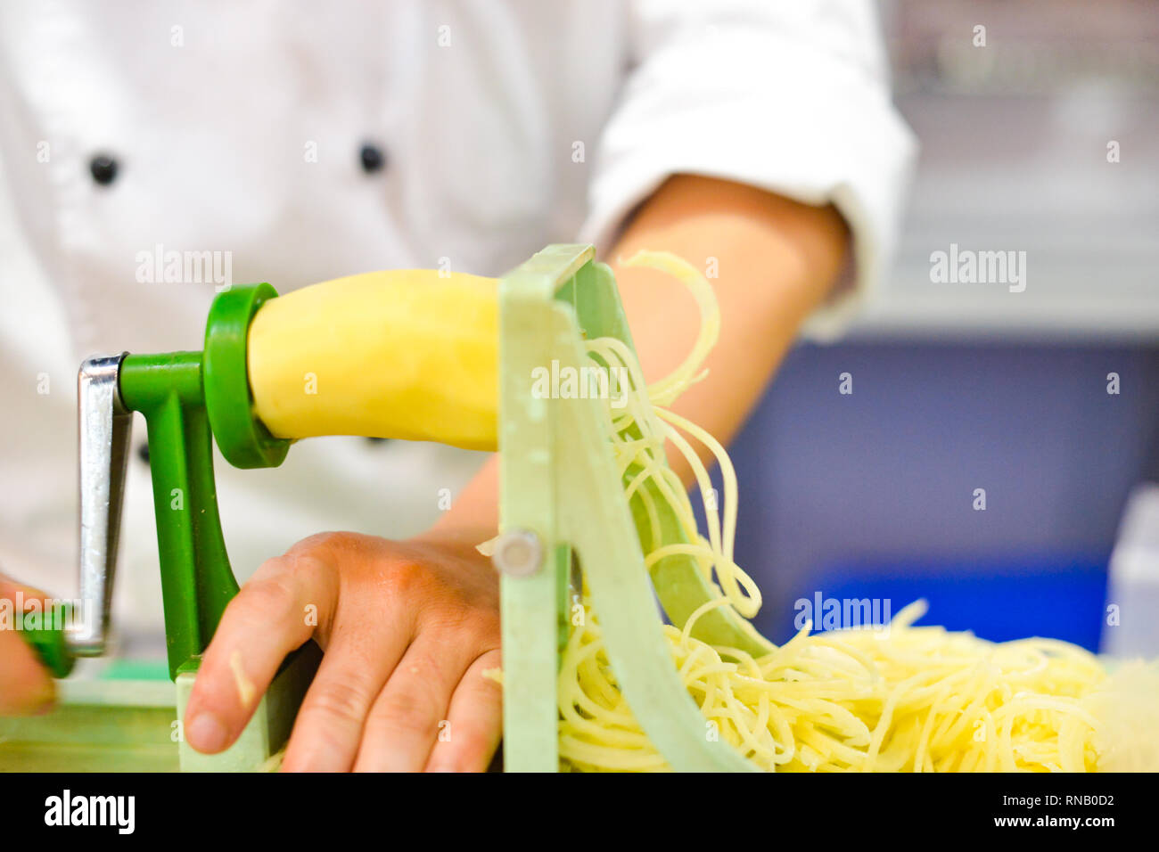 Pflanzliche Blade Spiralizer, Spirale Gemüse Hobel mit Kartoffeln Spaghetti auf Tisch Stockfoto