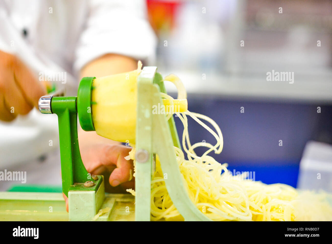Pflanzliche Blade Spiralizer, Spirale Gemüse Hobel mit Kartoffeln Spaghetti auf Tisch Stockfoto