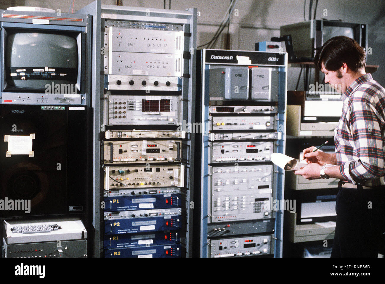 Ein Techniker, ein Wetter Physik Experiment, Cloud sammelt Daten von einem Computer Panel für die Leitung der Luftwaffe auf dem man Computer Interactive Data Acquisition System (MCIDAS) Abschnitt, Luftwaffe Geophysik Labor (AFGL). Stockfoto