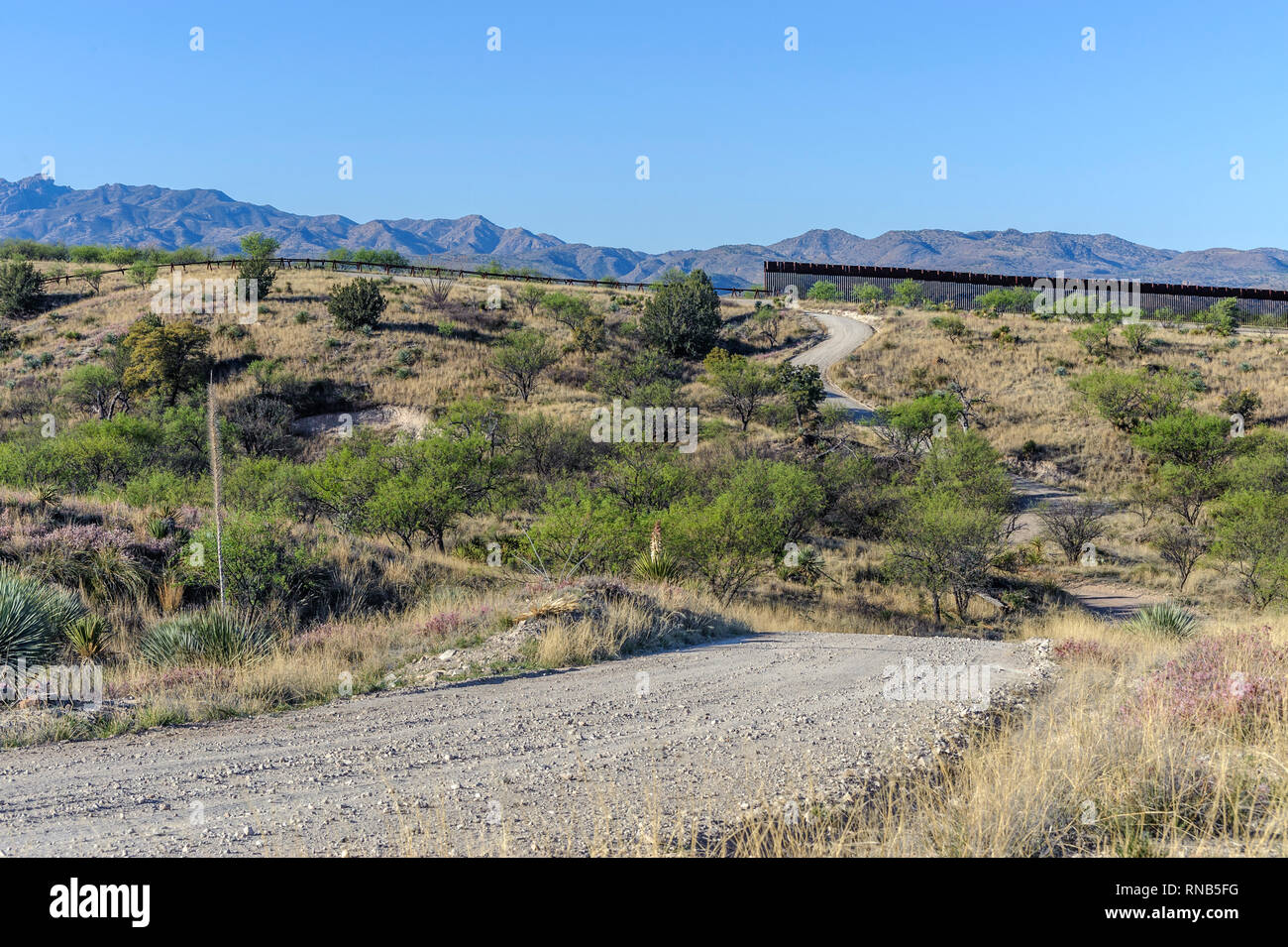 Uns Grenzzaun, zeigt hohe personensperre auf der rechten Seite an seinem östlichen Ende 7 Meilen östlich von Nogales AZ., mit Kraftfahrzeug Barriere" auf der linken Seite; April 2018 Stockfoto