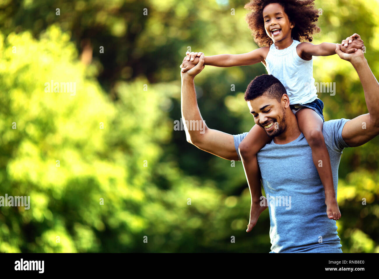 Porträt der jungen Vater, der seine Tochter, die auf dem Rücken Stockfoto