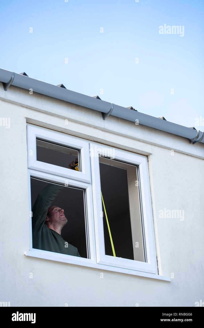 Bauarbeiter im Haus neue Windows-Installation Stockfoto