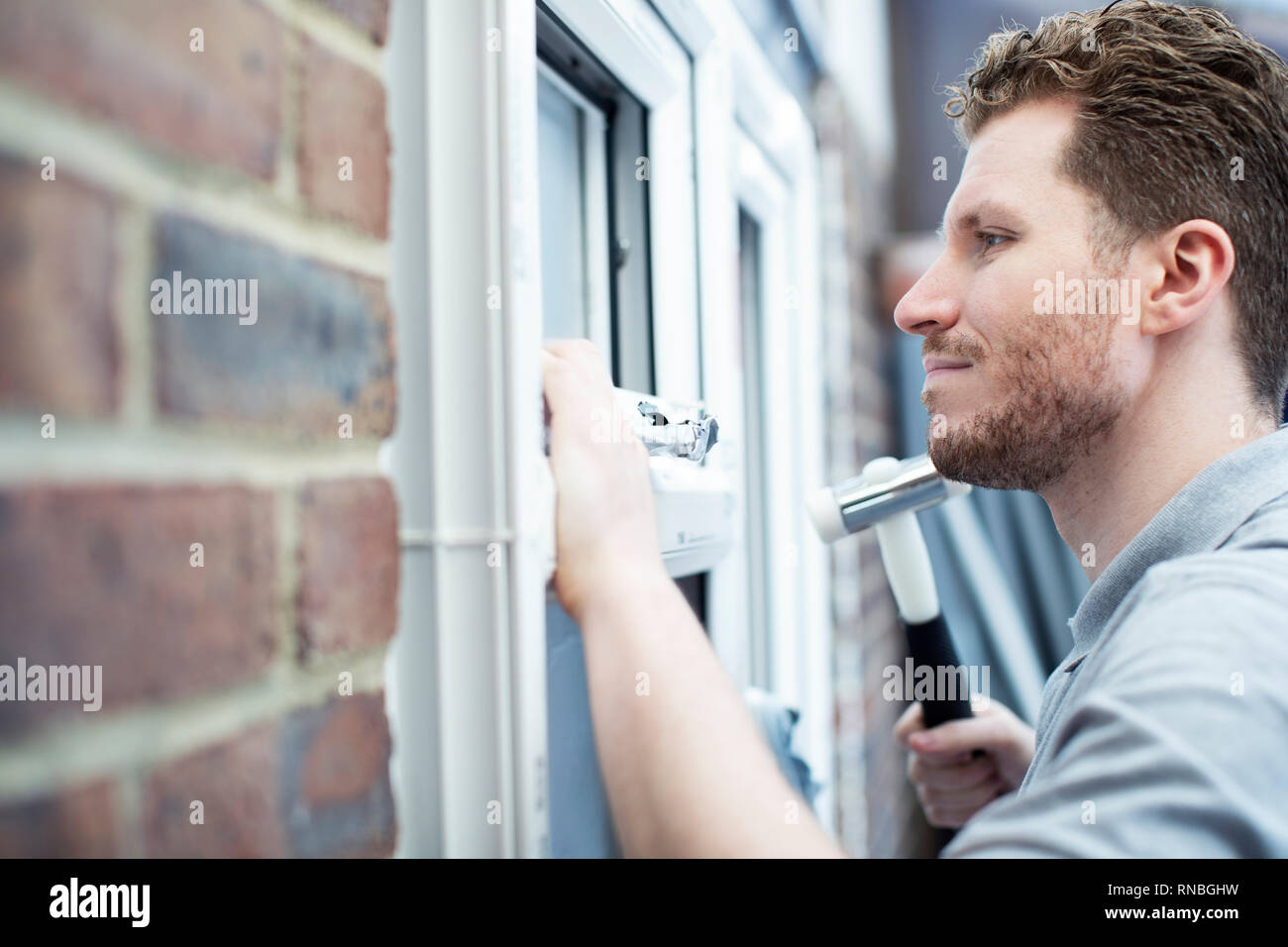 Bauarbeiter im Haus neue Windows-Installation Stockfoto