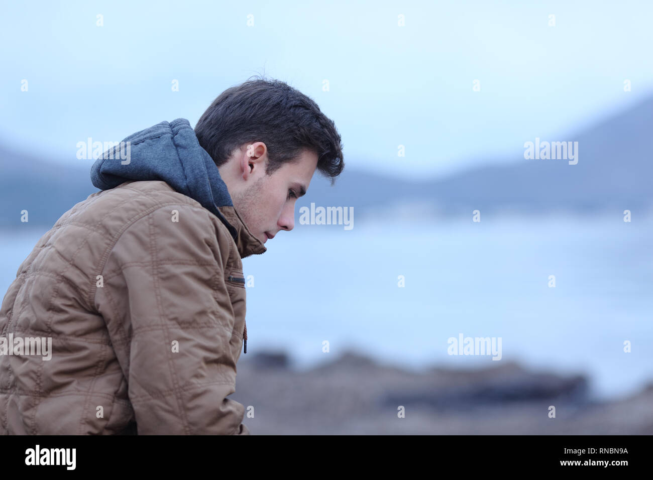 Seitenansicht ortrait eines traurigen Mann im Winter am Strand Beschweren Stockfoto