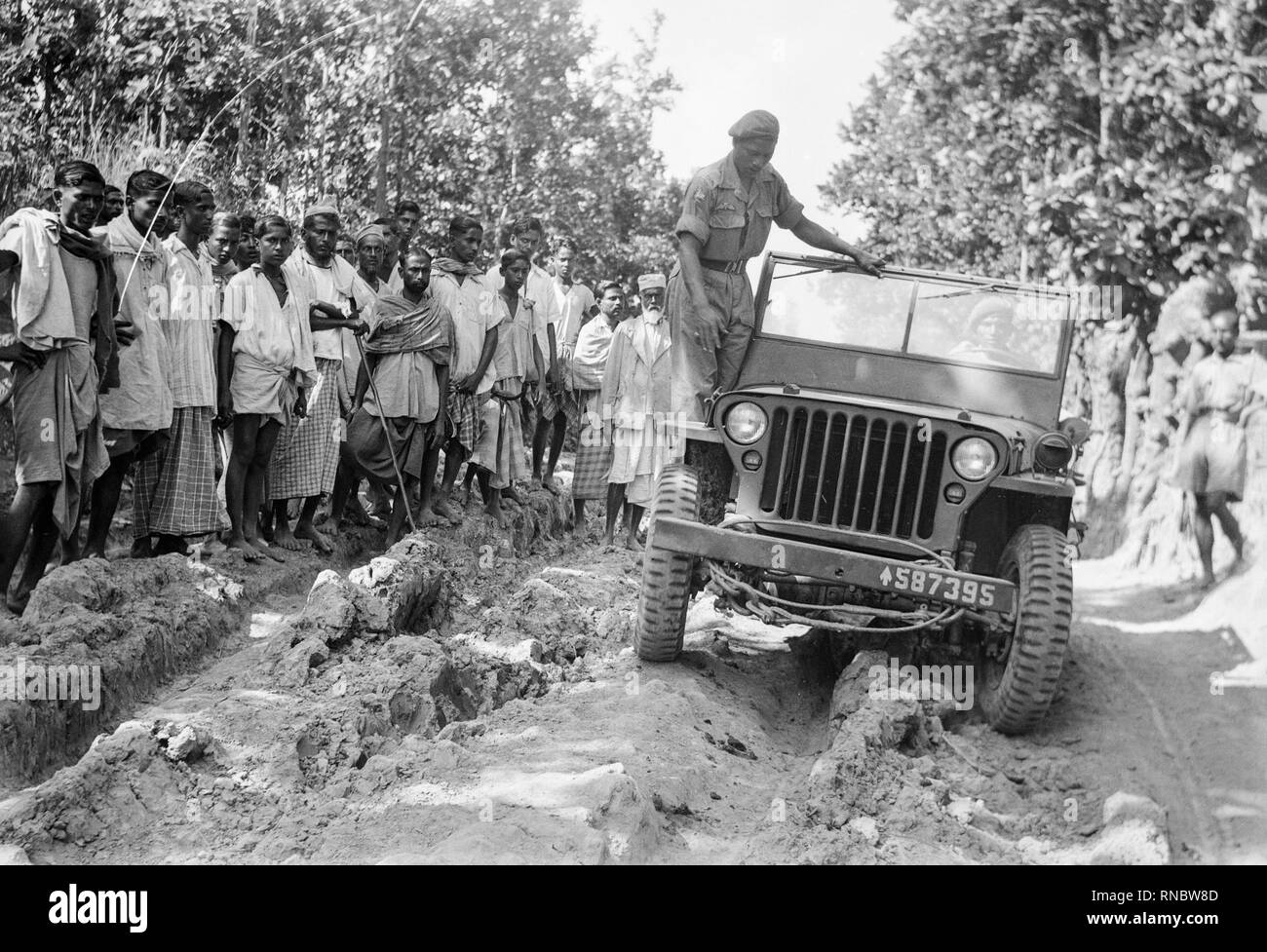 Ein Willys MB Jeep durch die indischen Truppen in der Mitte des zwanzigsten Jahrhunderts getestet. Lokale Leute schauen auf. Stockfoto