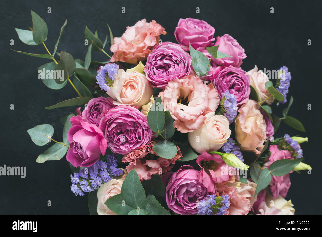 Blumenstrauß aus Rosen geschmückt mit Pfingstrosen und Eukalyptus. Hochzeit oder Geburtstag Blumen auf schwarzem Hintergrund Stockfoto