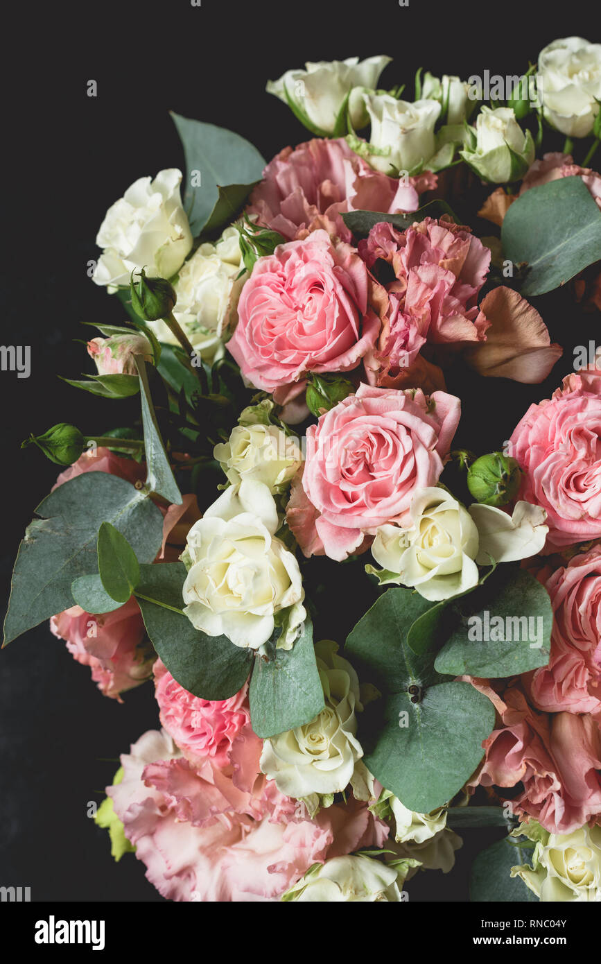 Blumenstrauß aus Rosen und Eukalyptus über schwarzen Hintergrund. Hochzeit, Geburtstag Blumen Blumenstrauß Stockfoto