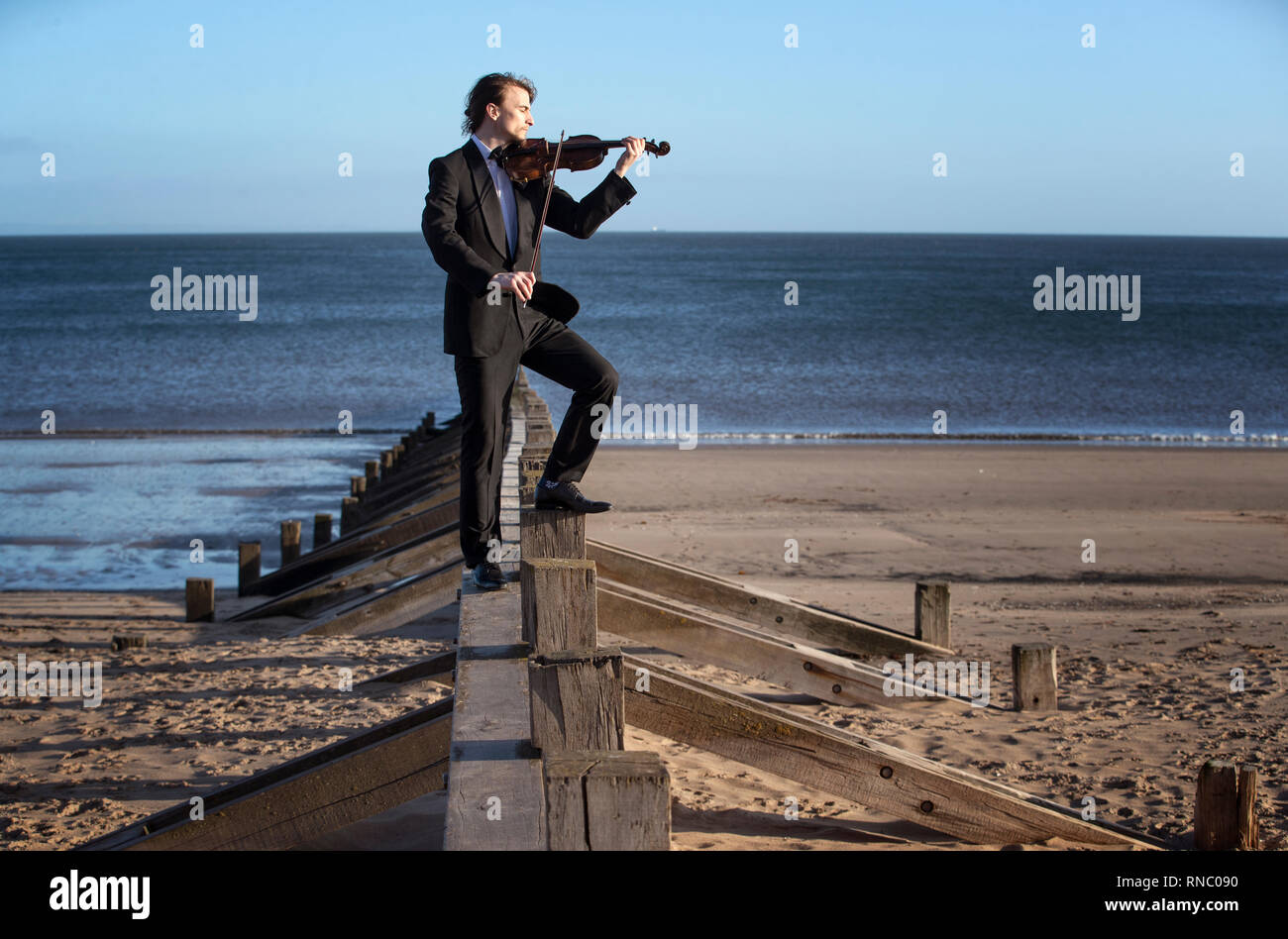 Musiker und Komponist Daniel Safford, aus Philadelphia, USA, spielt die Il Mare Violine, die aus Treibholz, auf Portobello Beach, Edinburgh, vor seiner Leistung an Schottlands International Marine Konferenz in Glasgow in dieser Woche. Stockfoto