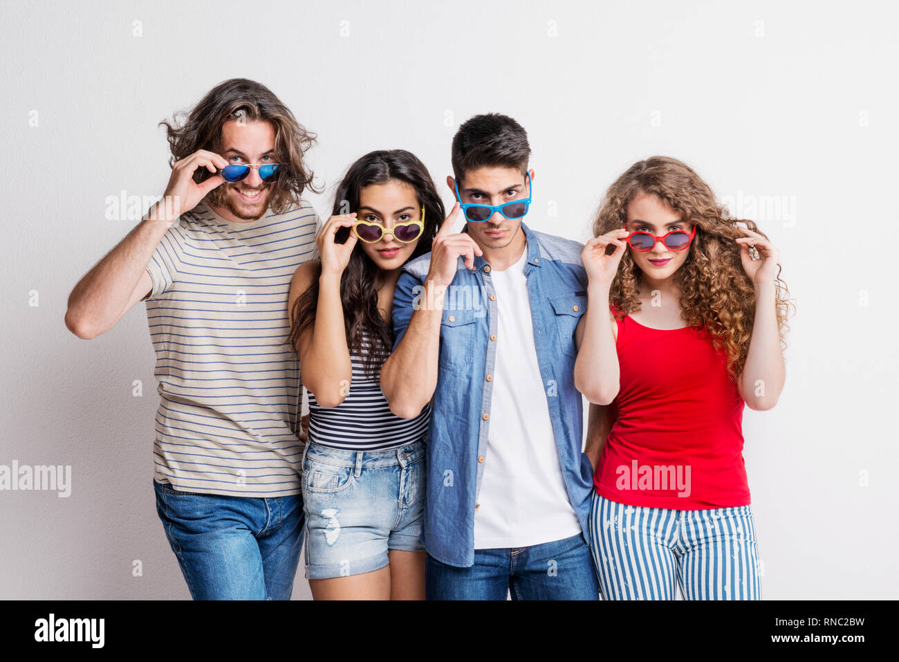 Portrait von freudige junge Gruppe von Freunden mit funky Sonnenbrillen stehen in einem Studio. Stockfoto