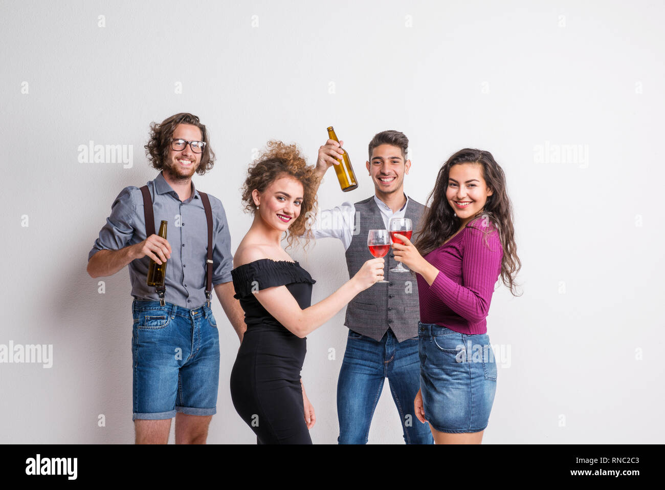 Porträt der jungen Gruppe von Freunden, die in einem Studio, Flaschen und Gläser. Stockfoto