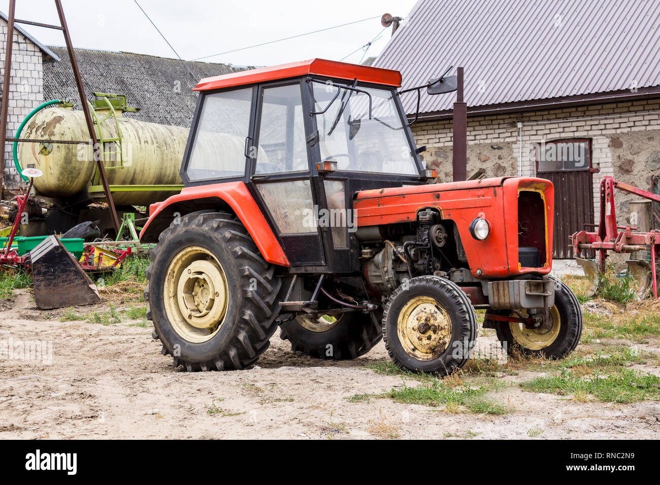 Alten Traktor für Arbeiten in einem Bereich, wo Mais und Gras für die Kühe gezüchtet. Allgemeine Ansicht der landwirtschaftlichen Maschine. Ausrüstung für eine Molkerei. Stockfoto