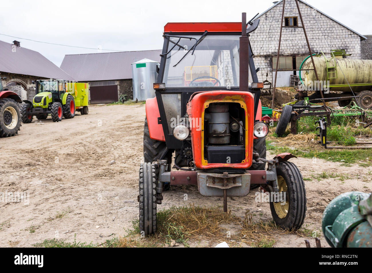 Alten Traktor für Arbeiten in einem Bereich, wo Mais und Gras für die Kühe gezüchtet. Vorderansicht einer landwirtschaftlichen Maschine. Ausrüstung für eine Molkerei. Stockfoto