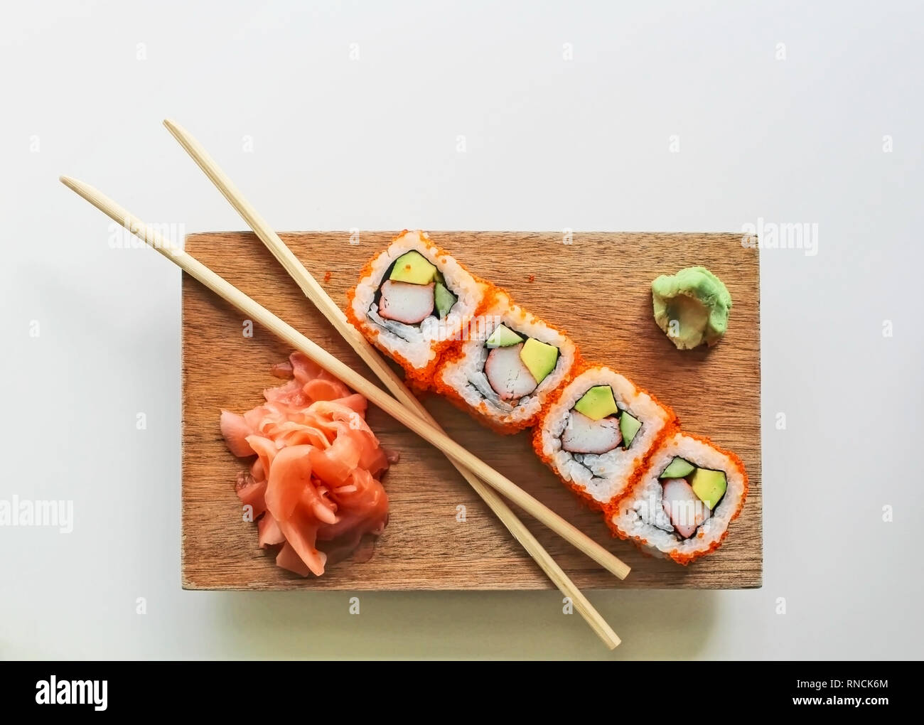 Stäbchen mit Kalifornien Sushi maki Rollen, Wasabi und Ingwer auf  Holzplatte mit grauer Hintergrund - Japanische Küche und Kultur  Stockfotografie - Alamy