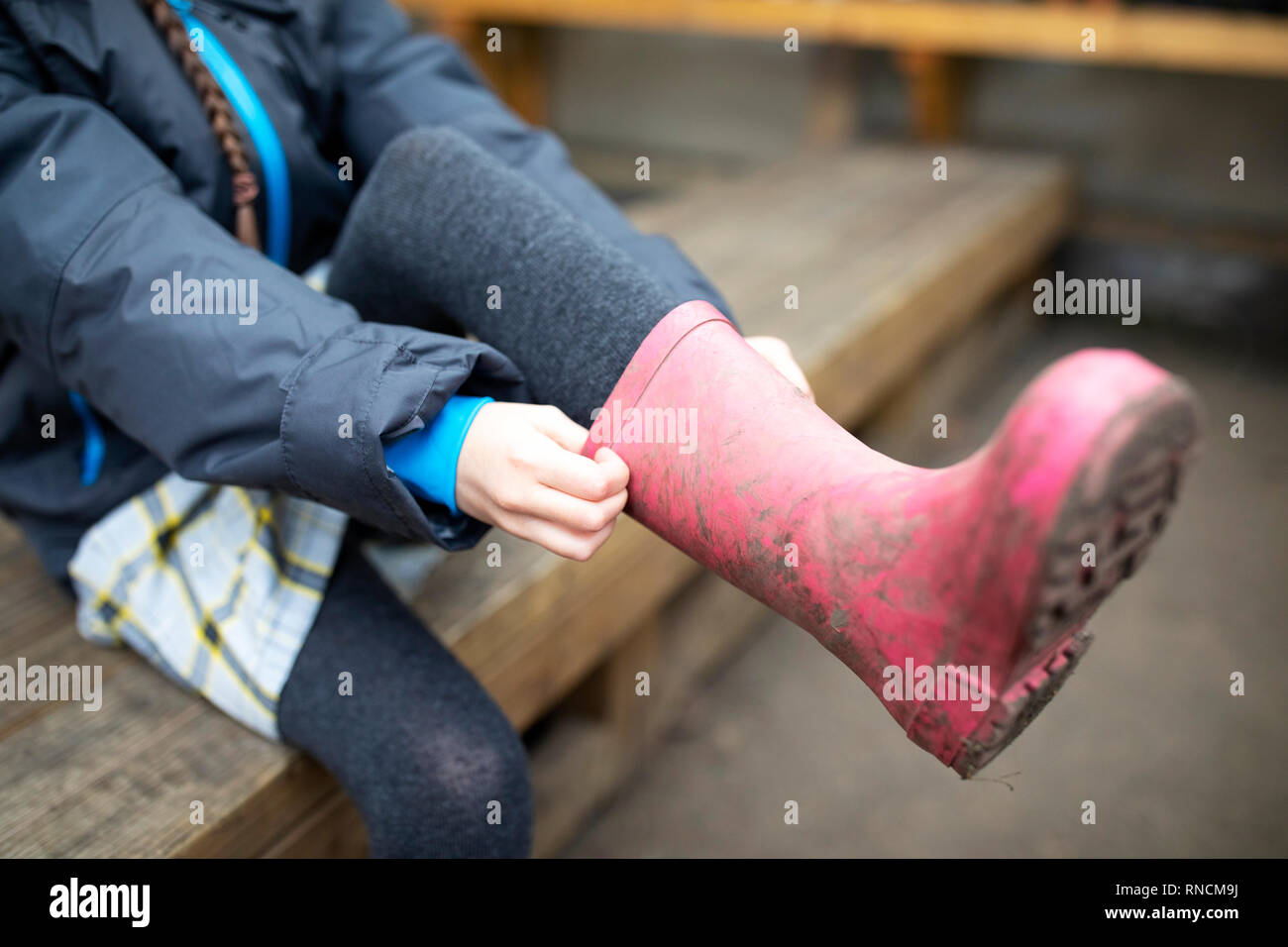 Grundschule im Alter von Mädchen ziehen an Rosa Gummistiefel Stockfoto