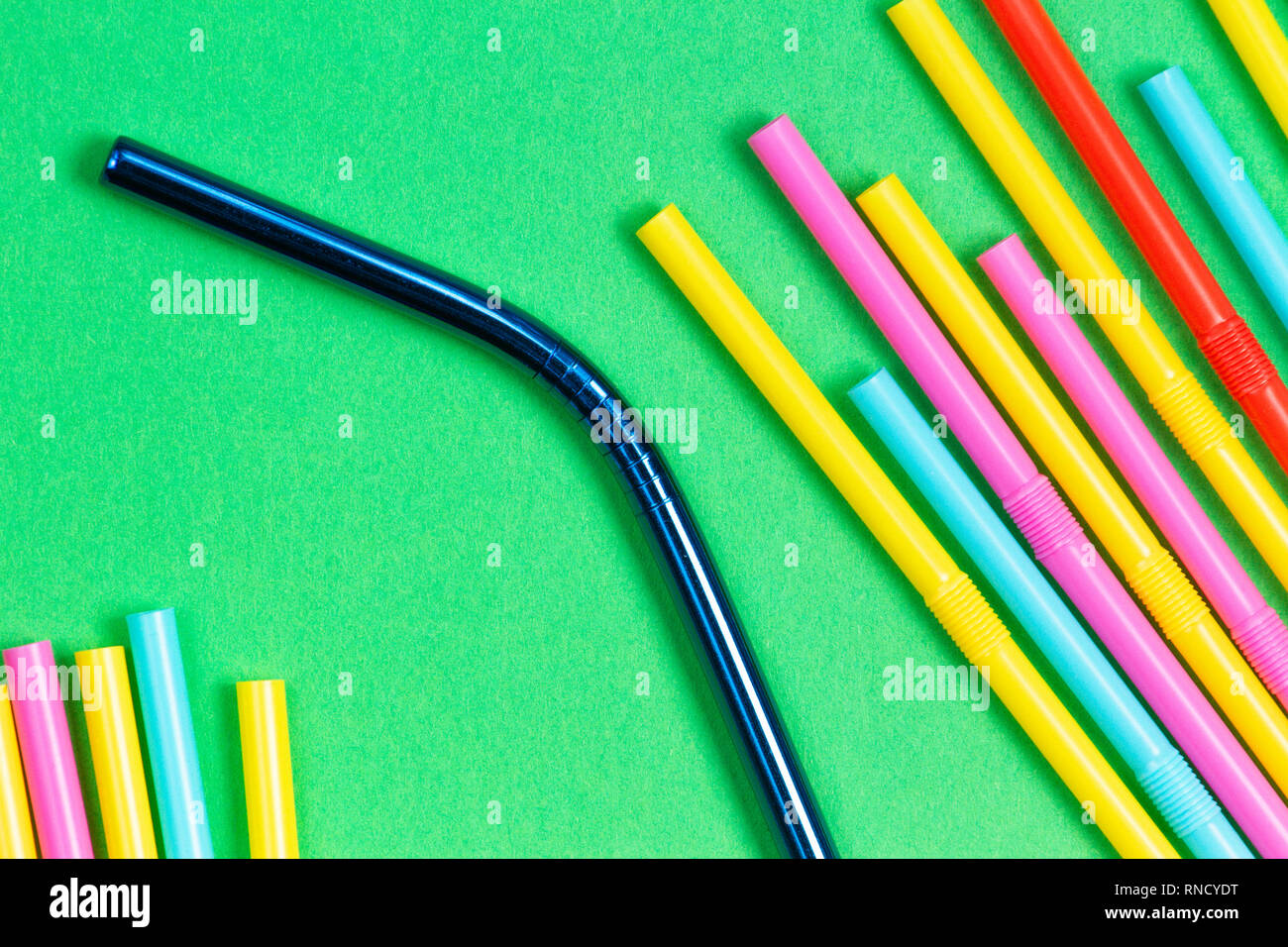 Edelstahl wiederverwendbare Trinkhalm mit Plastik Strohhalme auf grünem Hintergrund Stockfoto