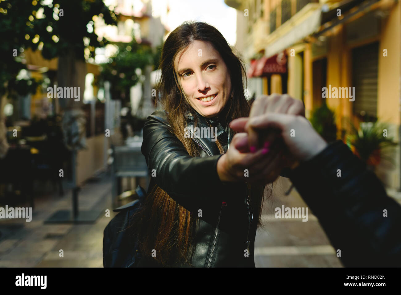 Junge Frau mit Arm ihres Freundes, während sie weg von den Läden ziehen fallen in Konsumismus zu vermeiden. Stockfoto