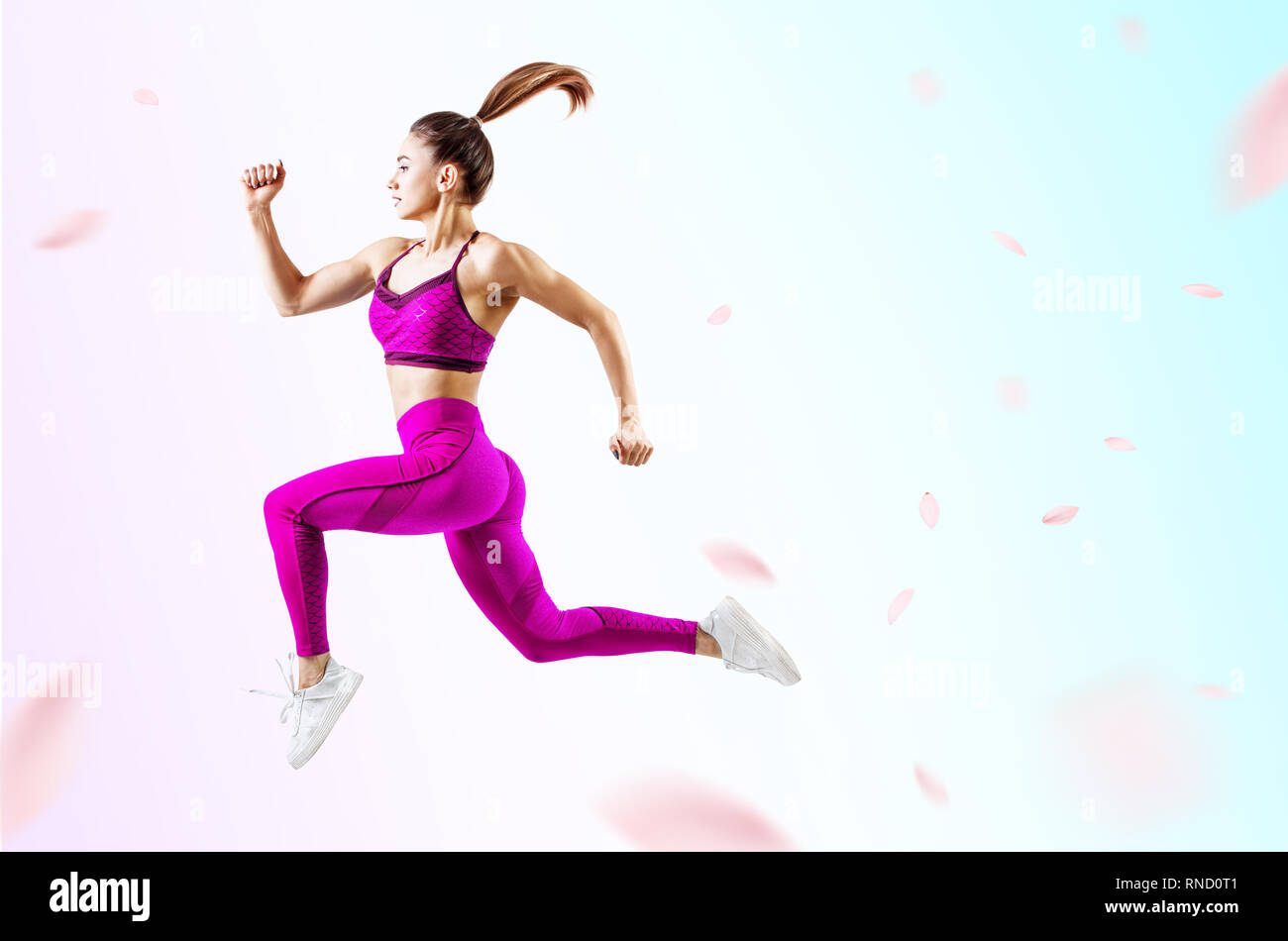 Junge Frau Läufer in Lila sportswear Sprung in der Luft. Stockfoto