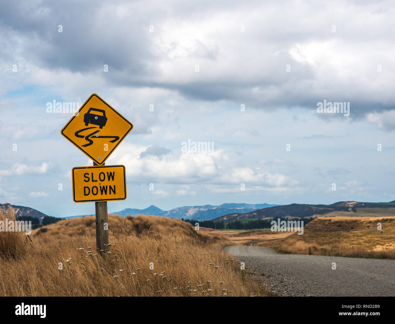 Slow Down Warnung Schild, nicht abgeschottete Schotterstraße, Ngamatea Station, Inland Mokai Patea, Central North Island, Neuseeland Stockfoto