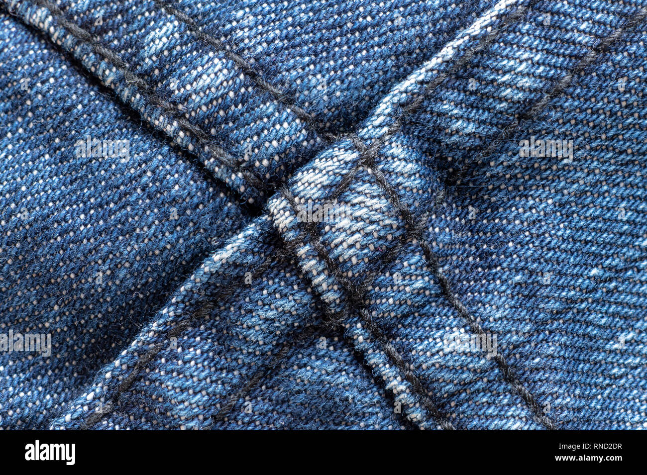 Denim oder grobe Baumwolle oder Jeans Material mit genähten Verbindungen für die Textilindustrie strukturierten Hintergrund in hellem Blau. Makroaufnahme Stockfoto