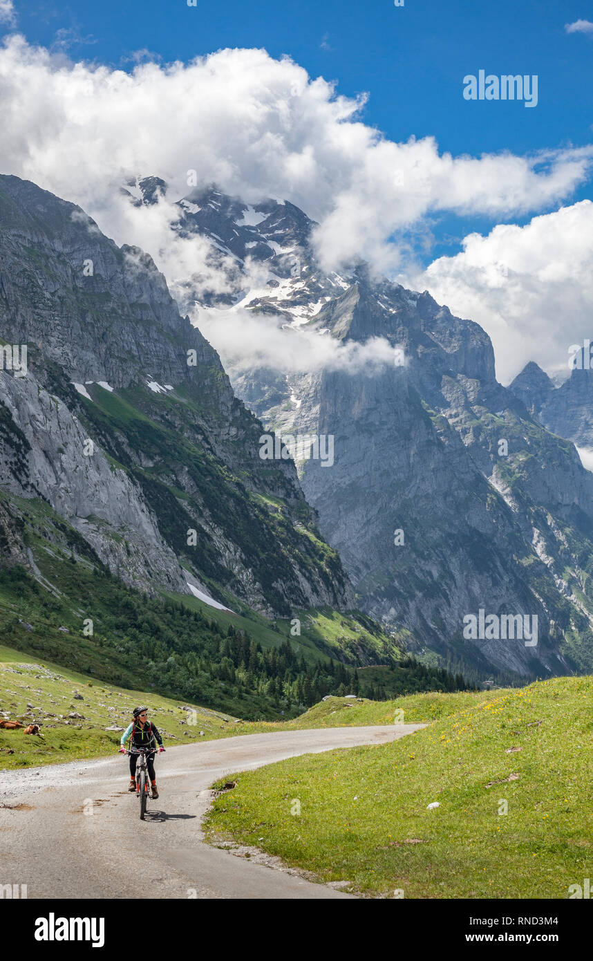 Schön und immer jung Senior Frau reiten Ihr e-mountainbike unterhalb der Eiger Nordwand, in der Nähe von Grindelwald, Berner Oberland, Schweiz Stockfoto