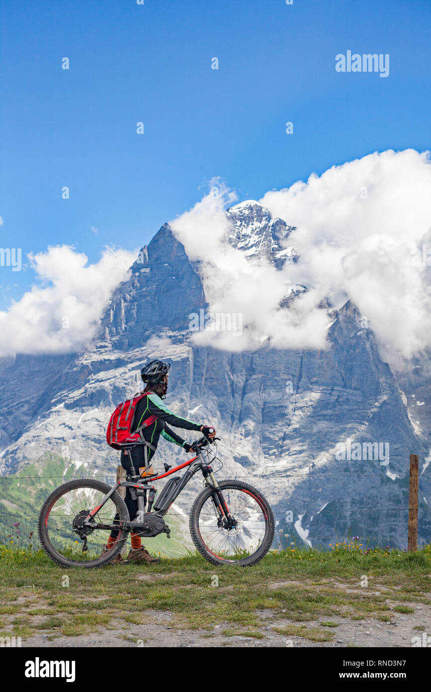 Schön und immer jung Senior Frau reiten Ihr e-mountainbike unterhalb der Eiger Nordwand, in den Schweizer Alpen in der Nähe von Grindelwald Stockfoto