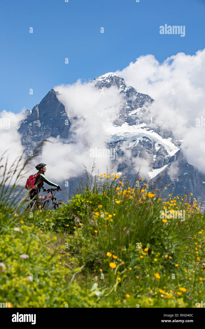 Schön und immer jung Senior Frau reiten Ihr e-mountainbike unterhalb der Eiger Nordwand, in den Schweizer Alpen in der Nähe von Grindelwald Stockfoto