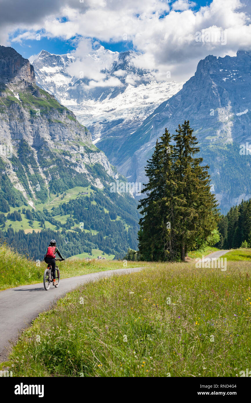 Schön und immer jung Senior Frau reiten Ihr e-mountainbike unterhalb der Eiger Nordwand, in der Nähe von Grindelwald, Berner Oberland, Schweiz Stockfoto