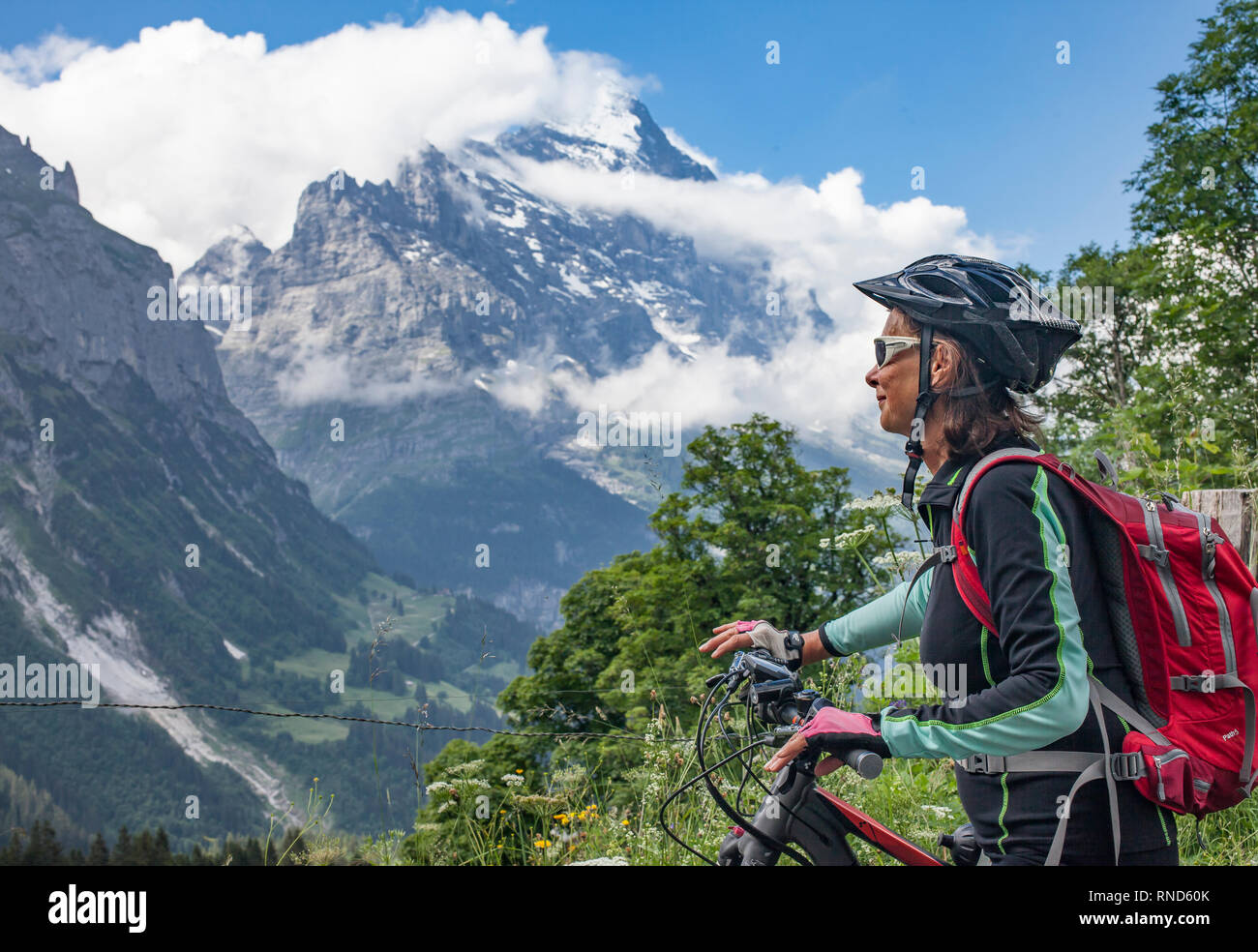 Schön und immer jung Senior Frau reiten Ihr e-mountainbike unterhalb der Eiger Nordwand, Jungfrauregion, Stockfoto