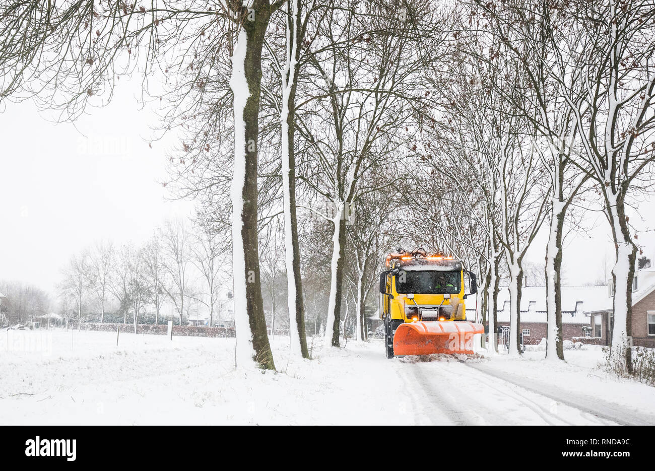 Stapler mit Schneepflug entfernt Schnee von vereisten Straße im Winter Stockfoto