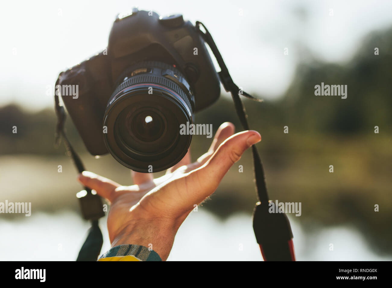 Nahaufnahme der Hand eines Mannes Fang eine Digitalkamera in der Luft. Person werfen, eine DSLR-Kamera in der Luft nah an seine Hand wieder zu fangen. Stockfoto