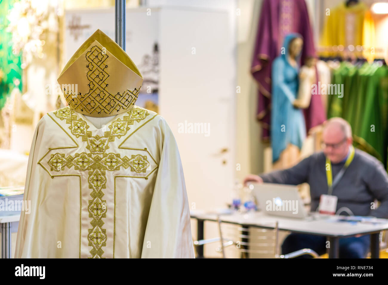 Bologna, Italien. 18. Februar, 2019. Paramente mit im Hintergrund stand Moderator Arbeiten am Laptop beim warten auf Besucher am Stand von MARANATHA in DEVOTIO religiöse Produkte und Service Ausstellung in Bologna, Italien. DEVOTIO ist eine neue und innovative Ausstellung. GoneWithTheWind/Alamy leben Nachrichten Stockfoto