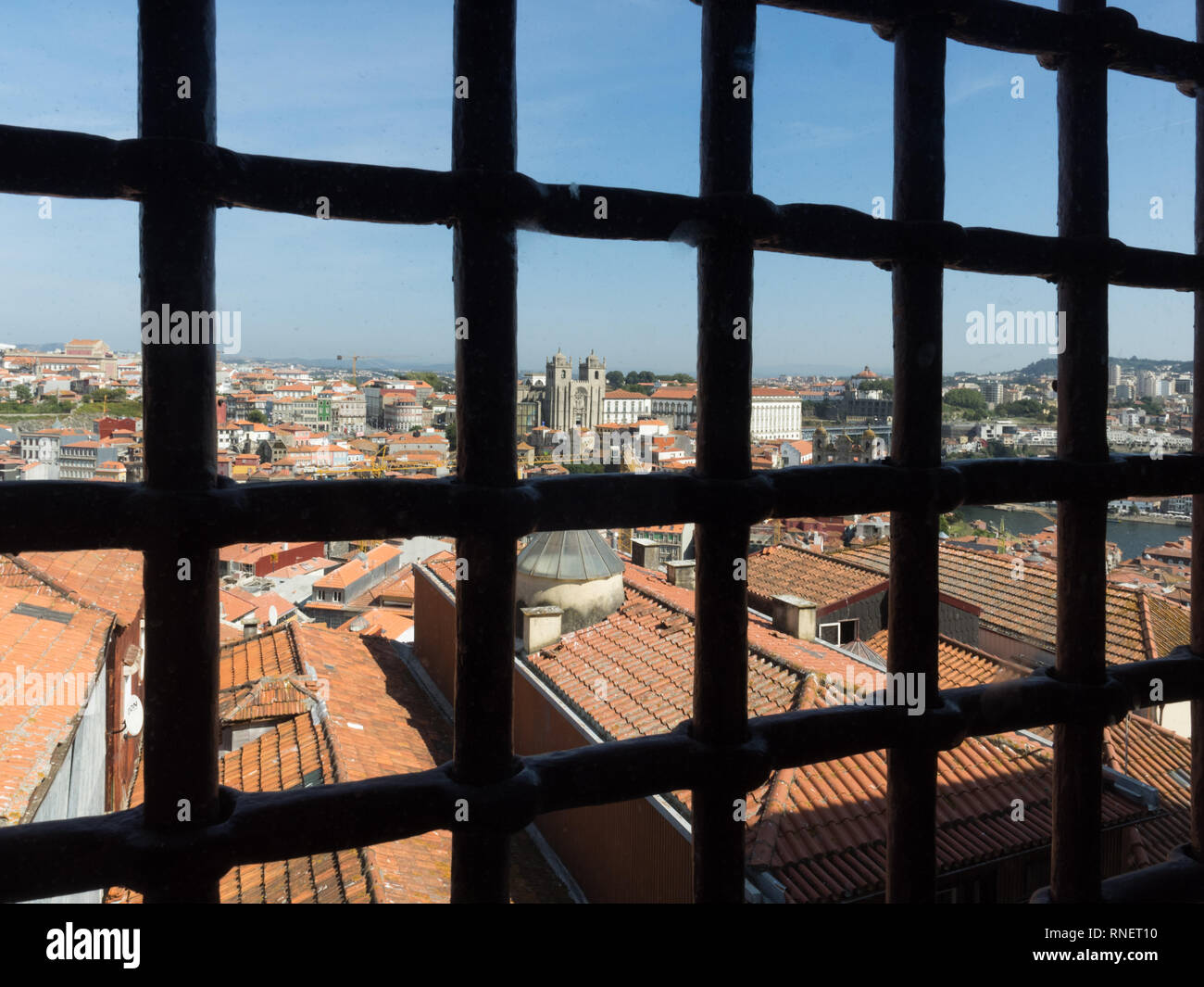 Ein blauer Himmel dachlandschaft Aussicht auf Porto Dächer von durch das alte Gefängnis Fenster Grill bars vergitterten Fenster Stockfoto