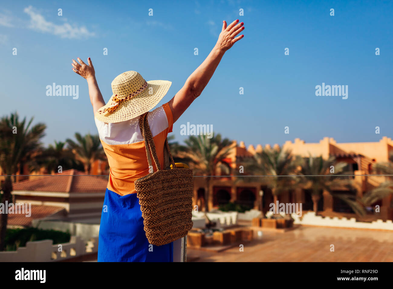 Gerne ältere Frau zu Fuß auf hotel Gebiet und die Hände. Sommer Urlaub in Ägypten. Elegante modische Optik Stockfoto Gerne ältere Frau zu Fuß auf hotel Gebiet und die Hände. Sommer Urlaub in Ägypten. Elegante modische Optik Stockfoto
