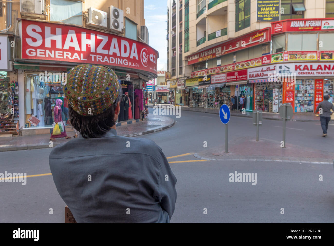 Nahaufnahme eines pakistanischen Mann von hinten gesehen, an einer Straßenecke der beliebten und ethnischen Stadtteil Deira in Dubai, Vereinigte Arabische Emirates wartet. Stockfoto