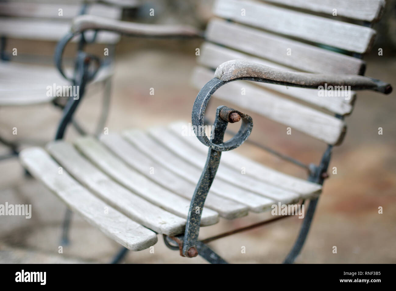 Eine alte verwitterte und abgenutzt aus Holz und Metall Stuhl mit flachen konzentrieren sich auf den Arm. Stockfoto
