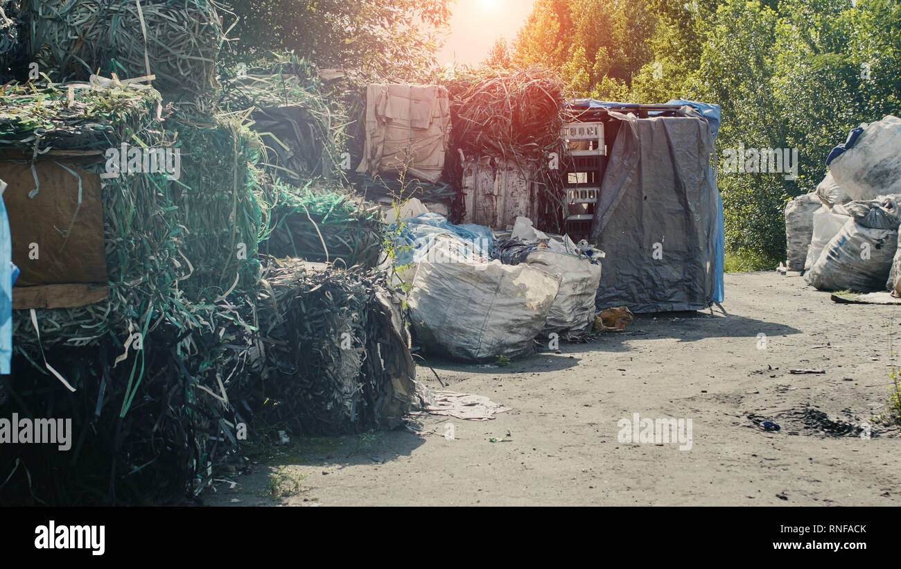 Große Berge von aus extrudiertem Polypropylen und Zellophan gegen einen Sonnenuntergang, Verarbeitung und Sortieren von Müll, Müll, Abfall Stockfoto