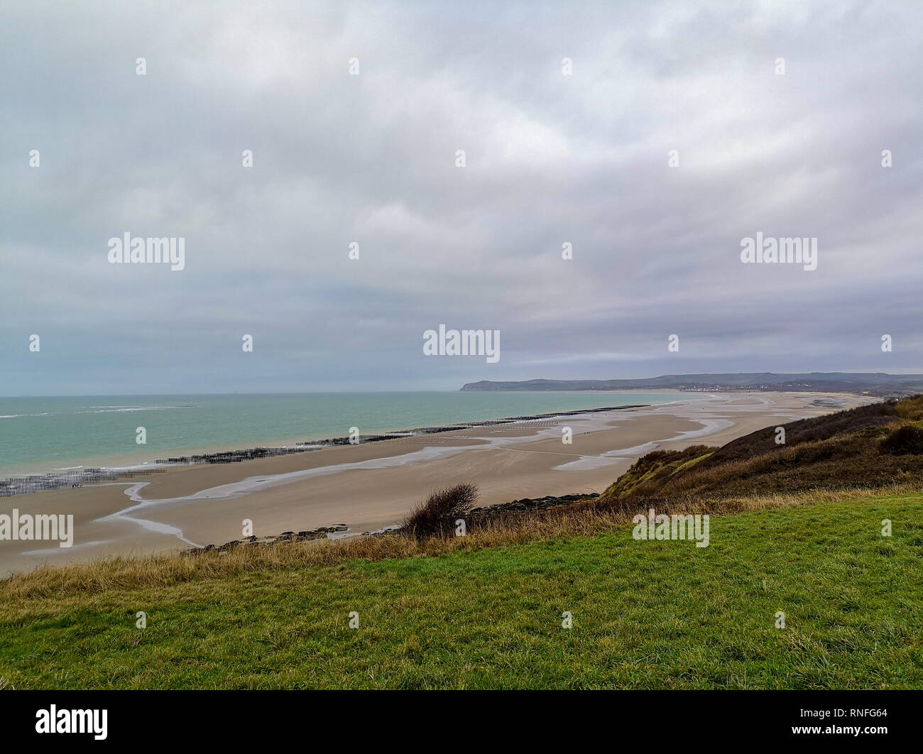Ebbe freigelegt eine große Muschelfarm in der Bucht von Wissant, Pas-de-Calais, Nord Frankreich. Blick vom Cap Gris-Nez auf - Cap Blanc Nez. Stockfoto
