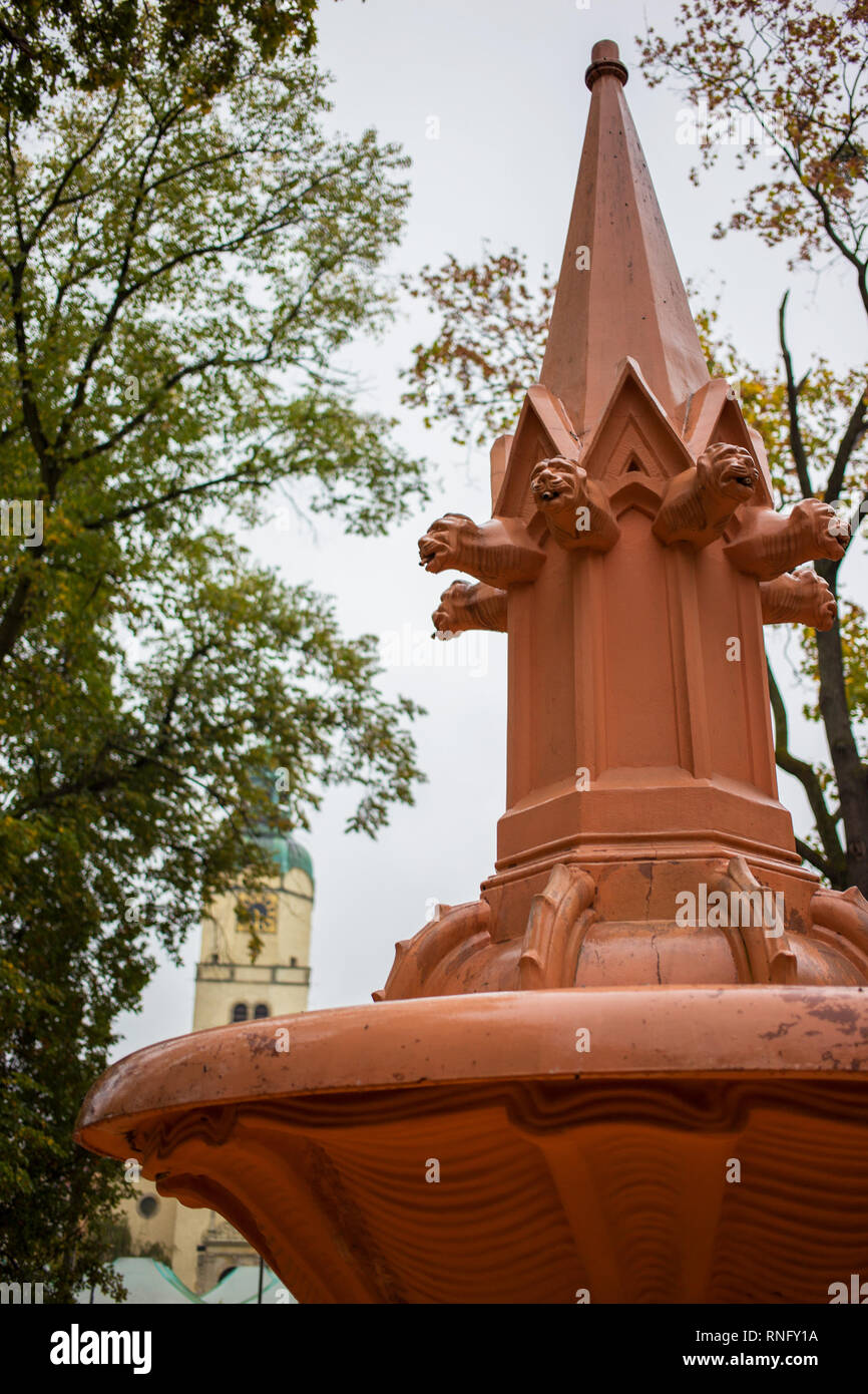 Orangefarbene Brunnen im Park in der Nähe Horde Markt in Poznan hat es Wasser ausgeschaltet entfernt, gibt es ein Kirchturm im Hintergrund Stockfoto