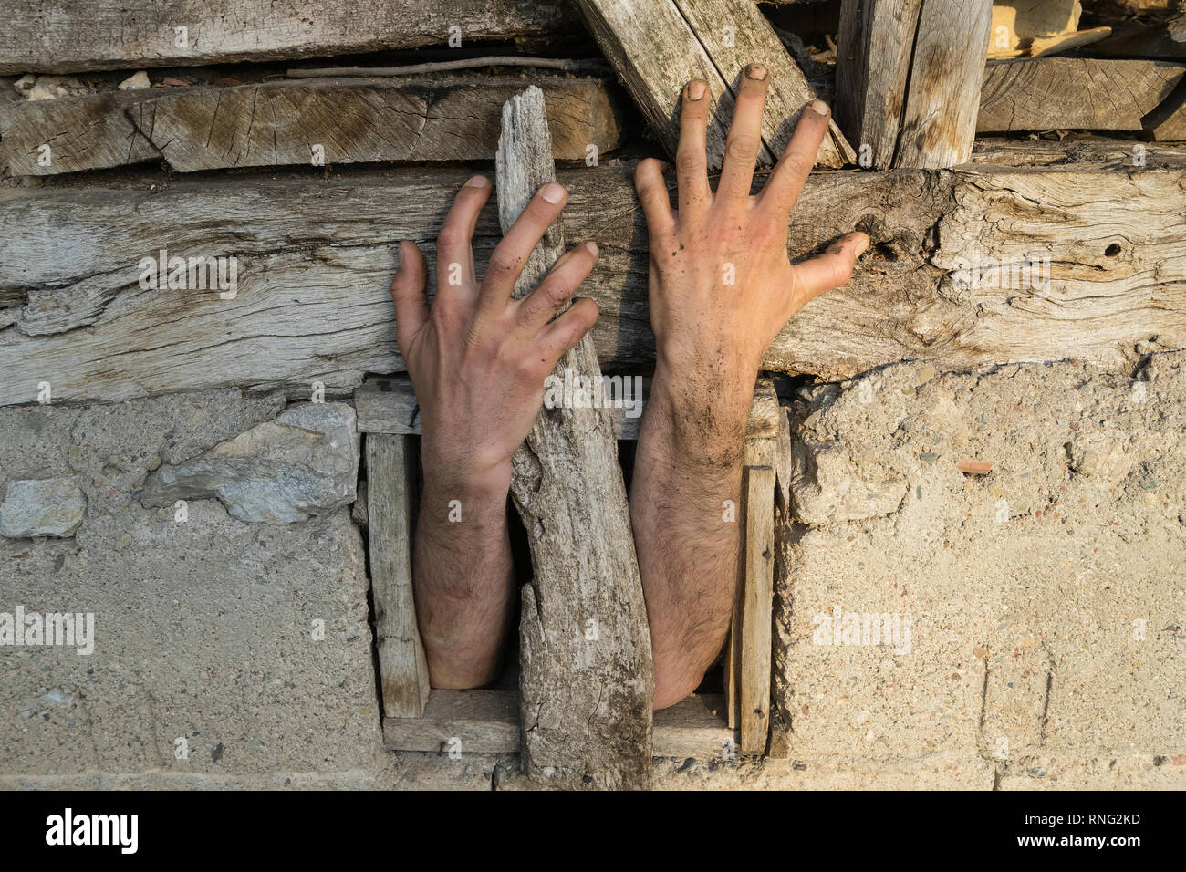 Hände greifen von einem kleinen Fenster aus Schlamm und Steinen im Haus im Balkangebirge Region Ost Serbien. Stockfoto