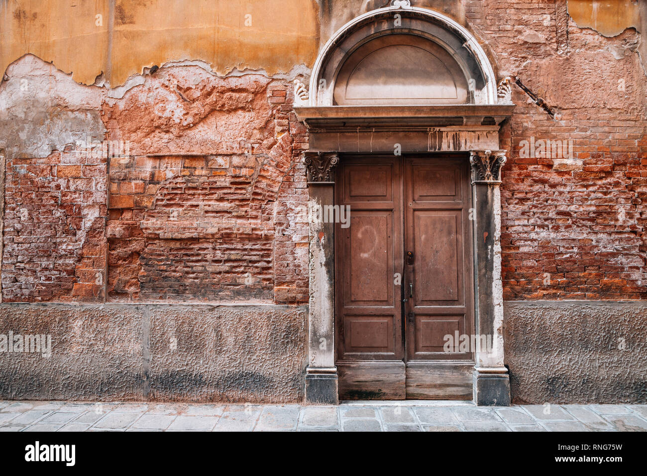 Alte Mauer aus Stein und Holz Tür an Venezianischen alte Straße in Italien Stockfoto