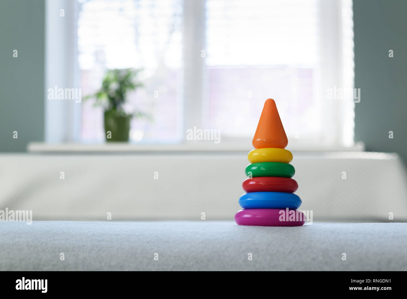 Farbige Pyramide Spielzeug auf weißen Bett. Kindheit Konzept Stockfoto