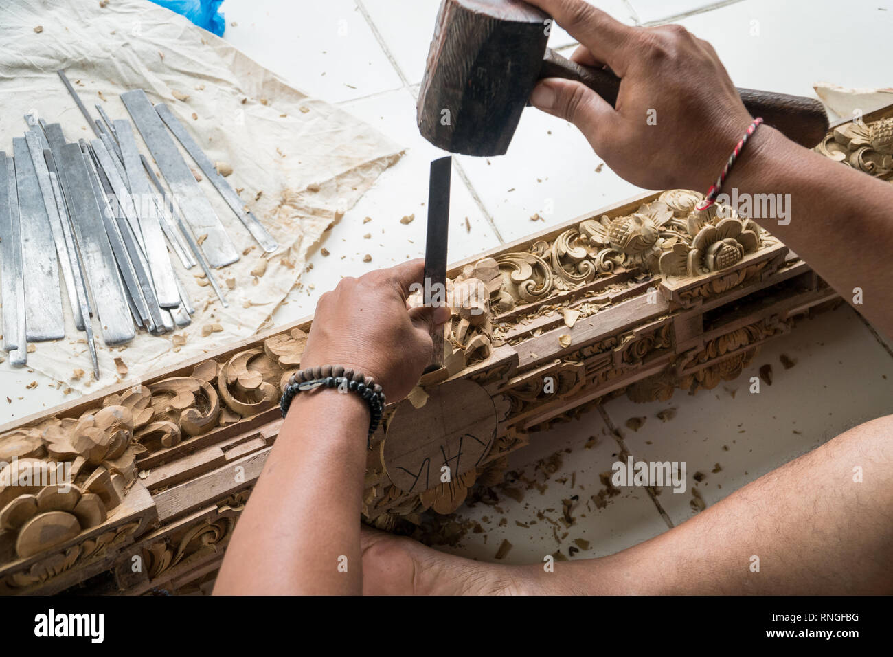 Die Hände eines Zimmermanns die traditionelle Holzschnitzerei in Bali, Indonesien. Lokale handwerkliche Tradition Konzept Stockfoto